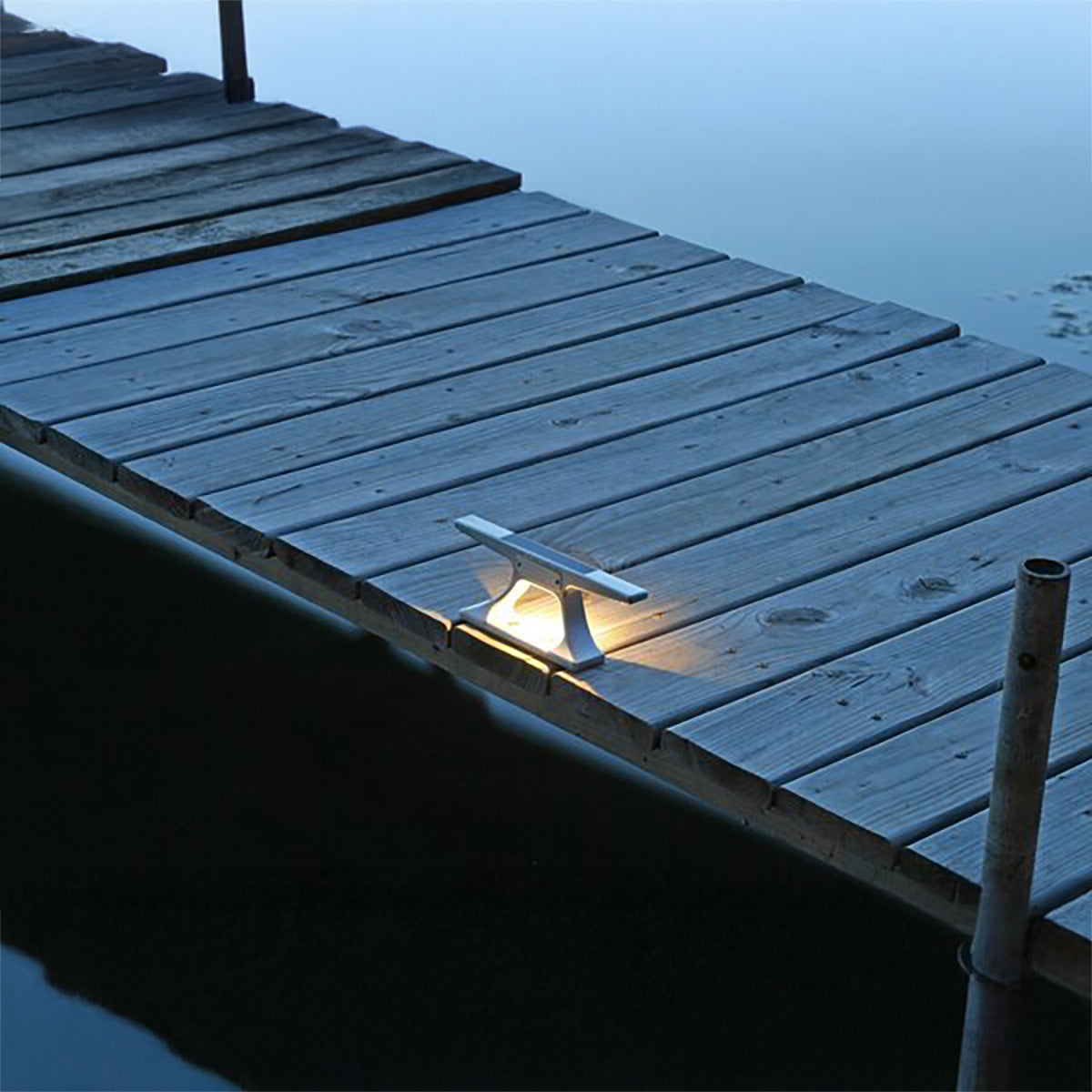 Wooden dock with a light fixture on a dark evening