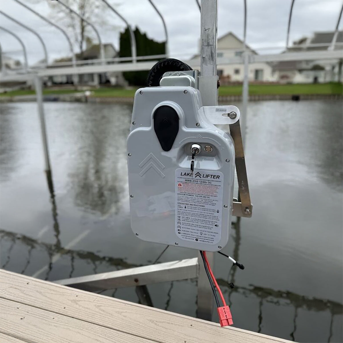 Lake lifter attached to a dock with water and houses in the background