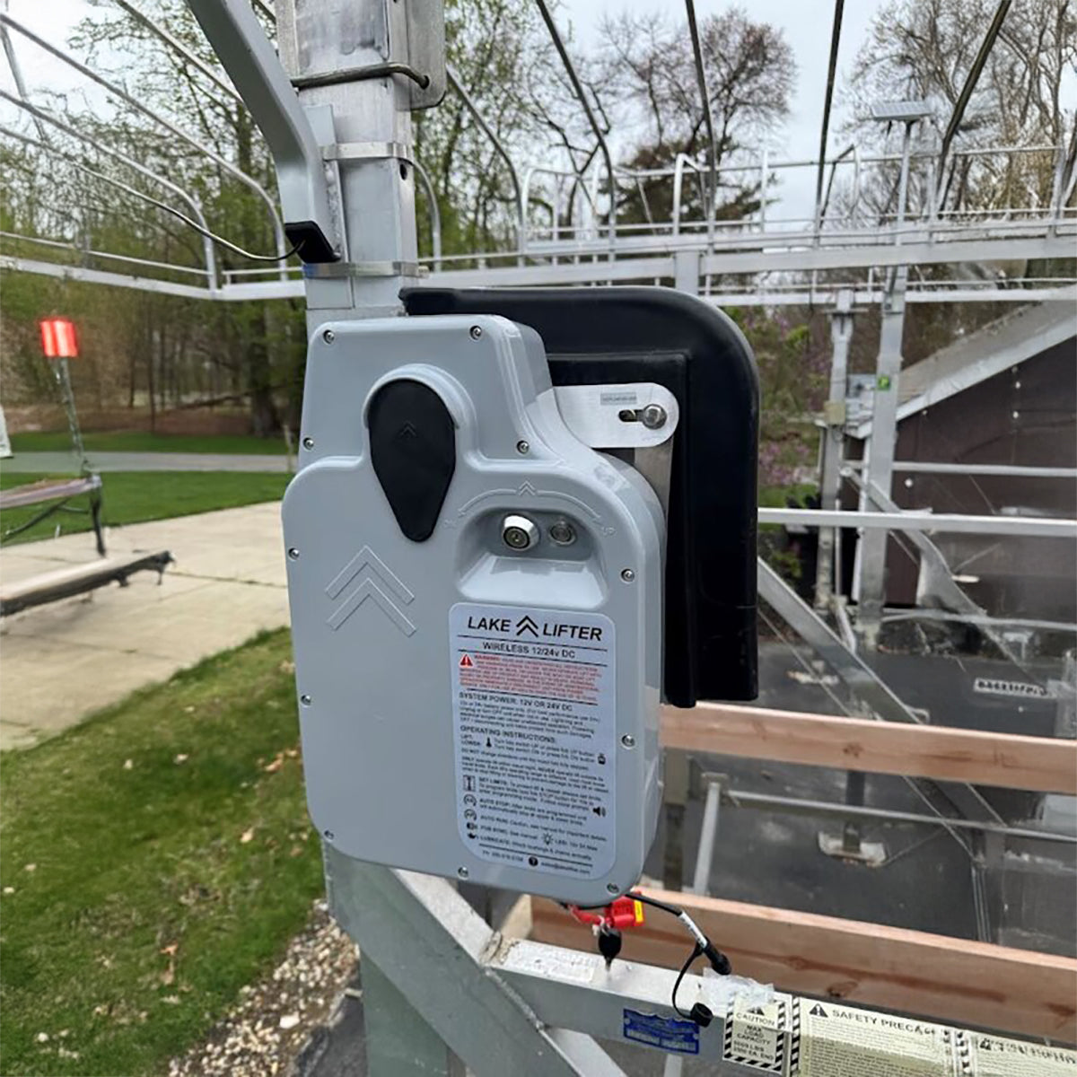Lake Lifter device on a metal structure with a background of trees and a building.