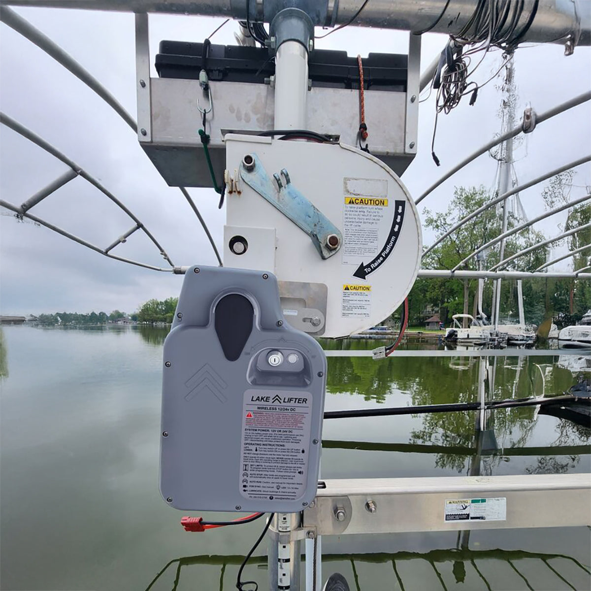 Marine winch system with Lake Lifter branded control panel on a boat, with water and sky in the background.