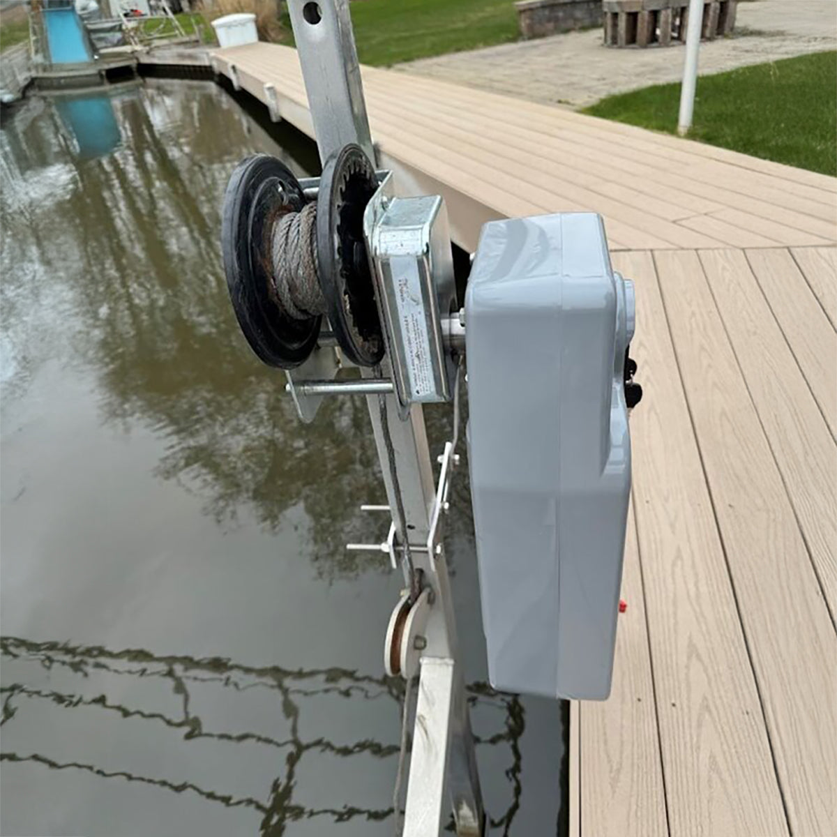 Electrical winch on a dock with water and deck in the background