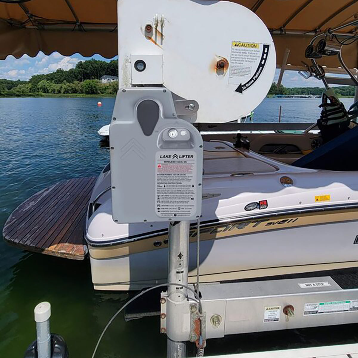 Boat lift mechanism on a dock with water and trees in the background