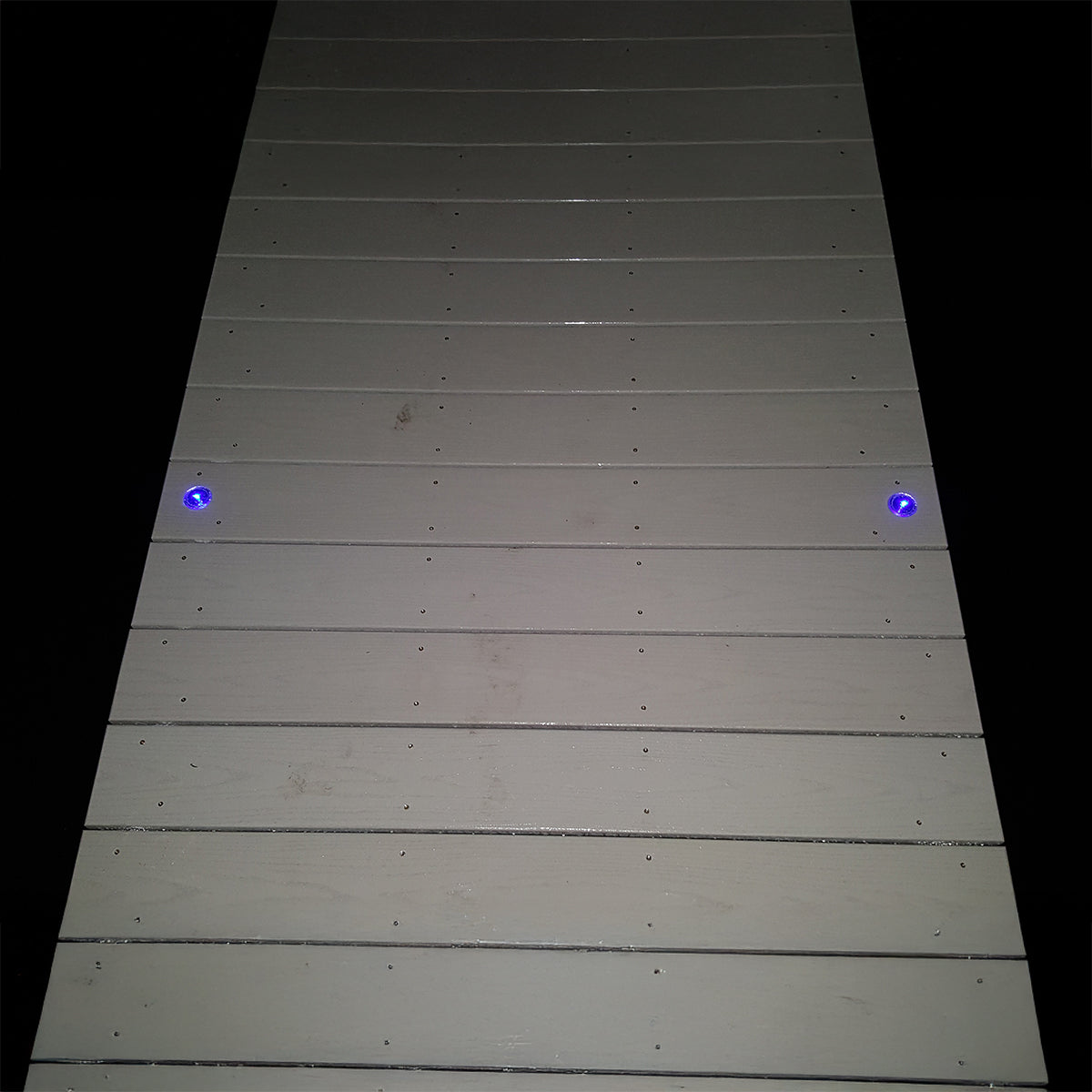 Wooden deck with blue lights on a black background