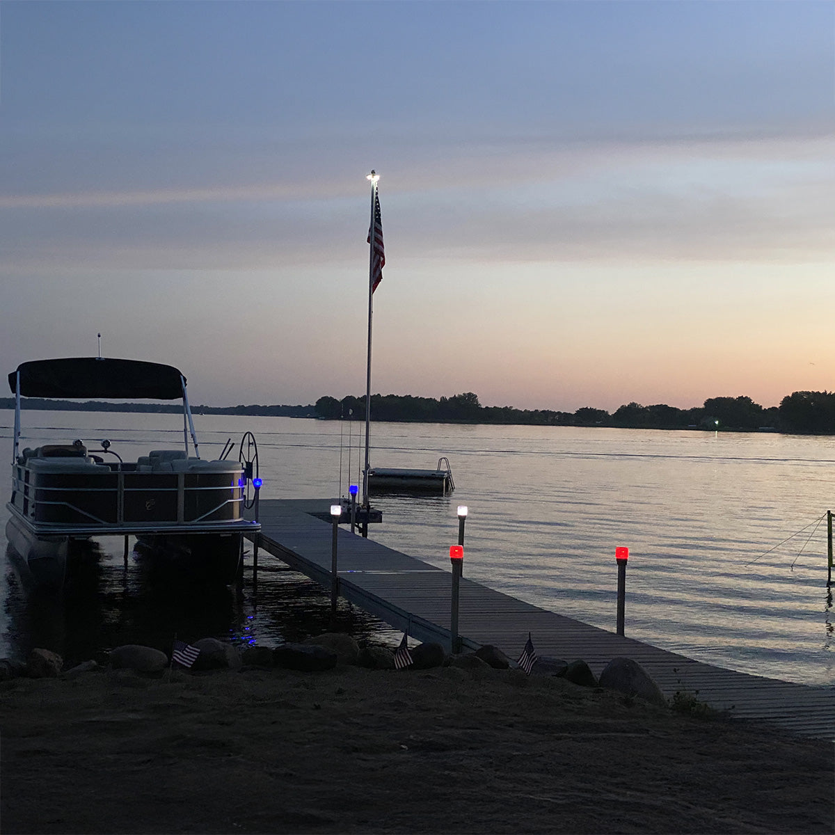 Boat docked at a pier with an American flag during sunset.