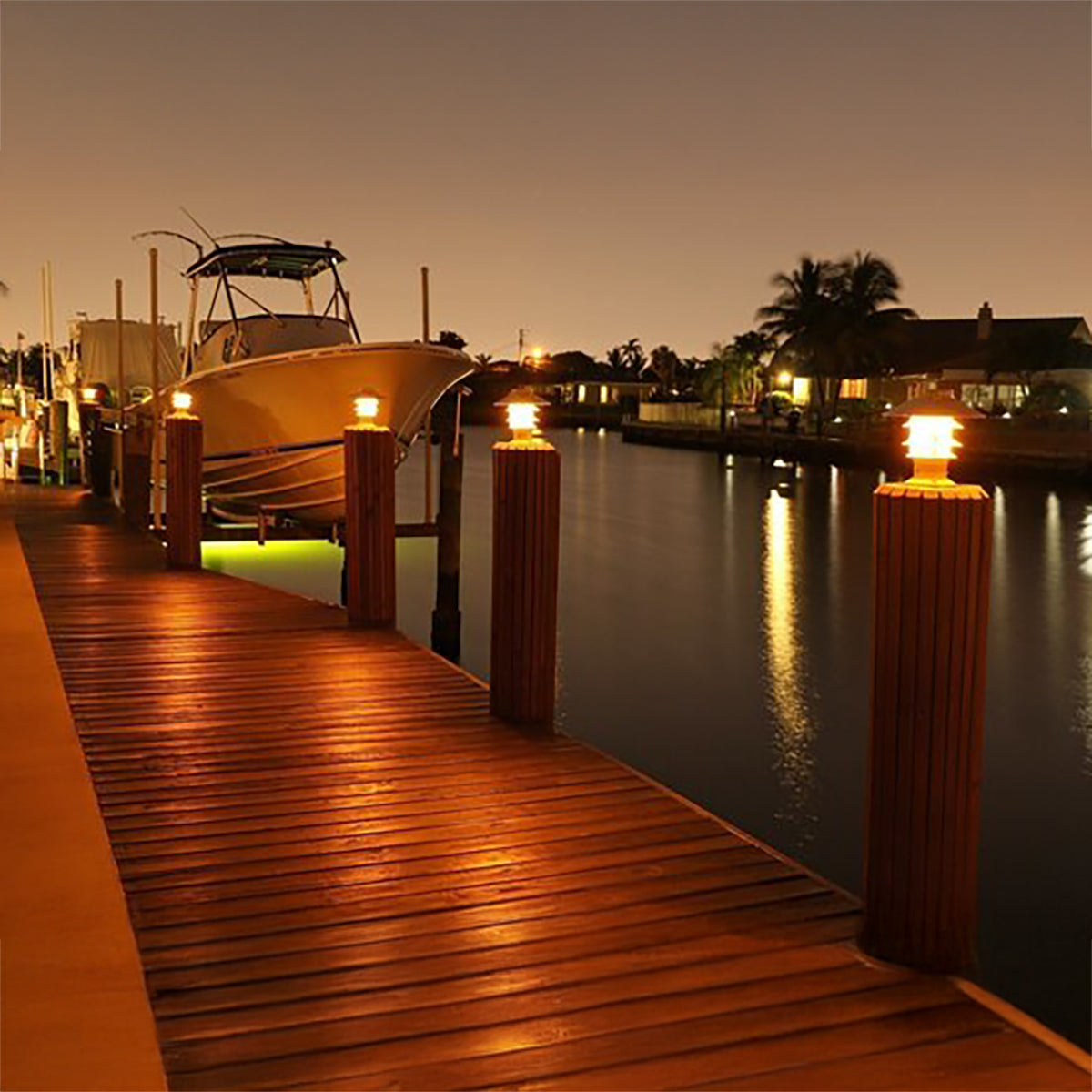 Wooden dock with a boat at night, illuminated by lights.