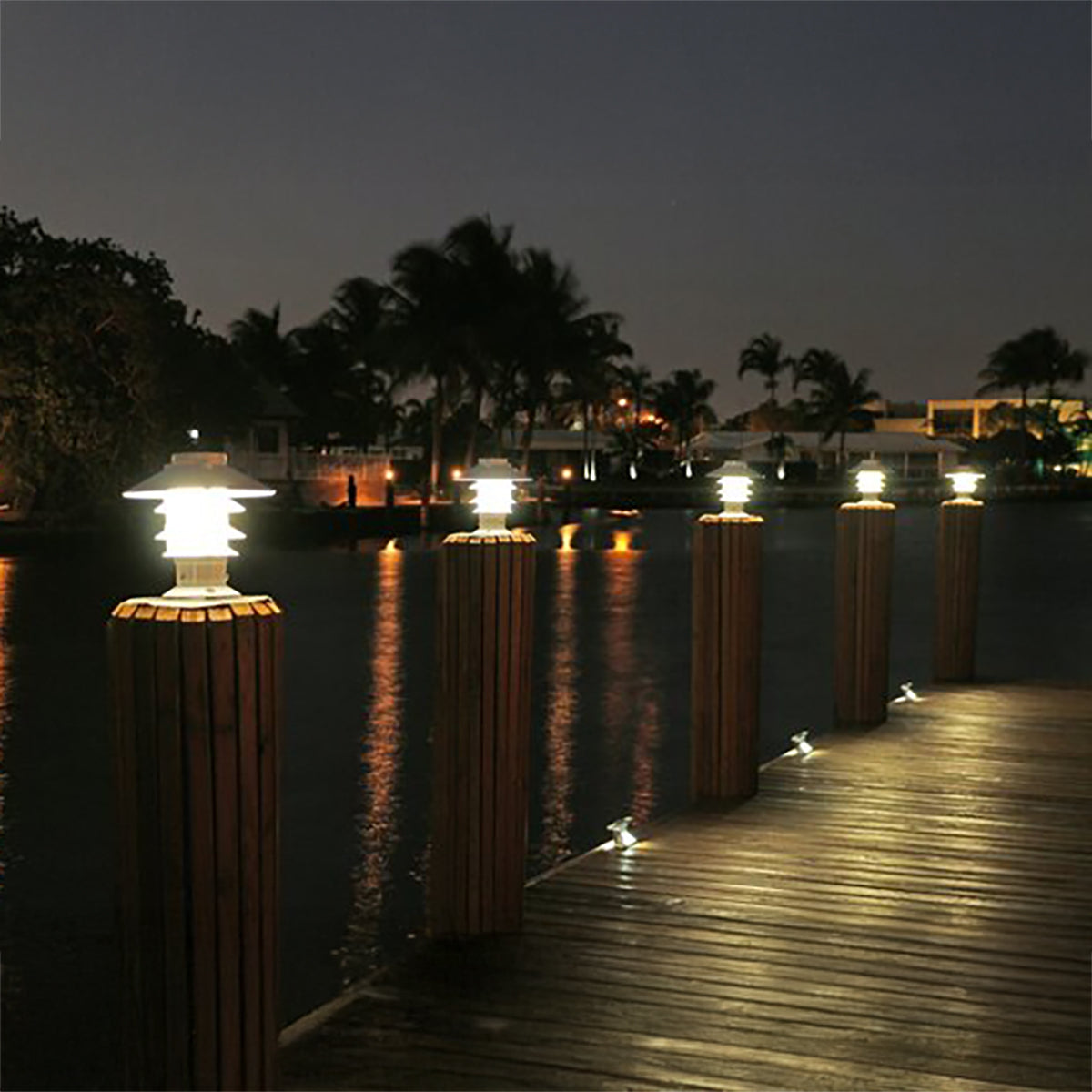 Decorative outdoor lights on posts along a dock at night.
