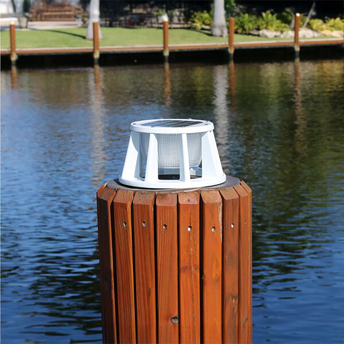 Solar light on a wooden post by a body of water