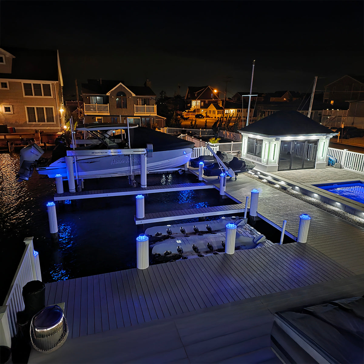 Marina at night with illuminated docks and buildings