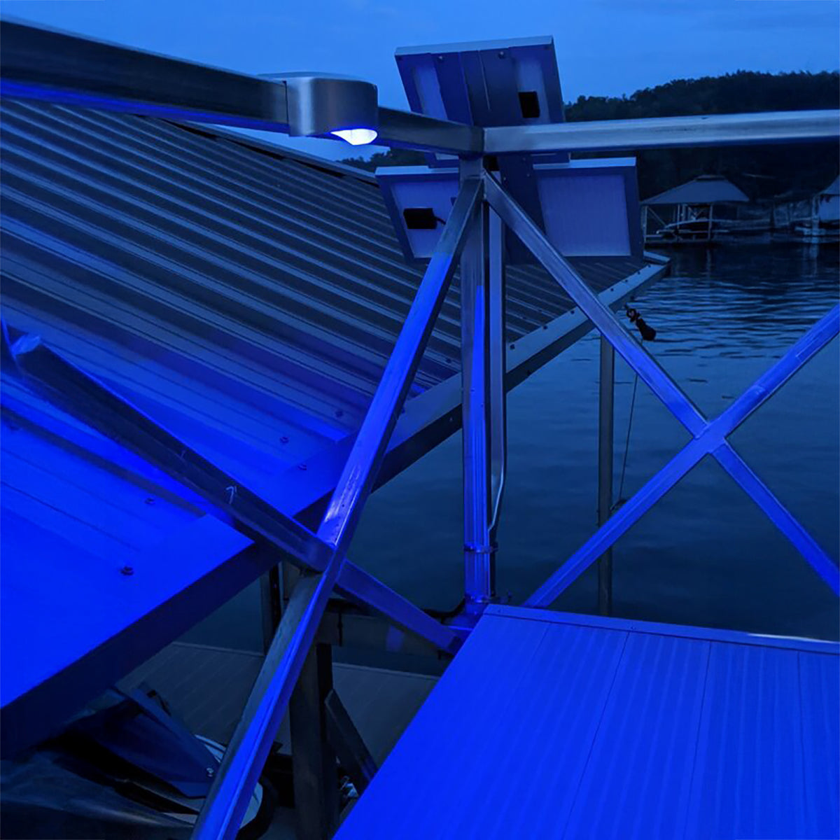 Blue-lit dock with metal structure and water in the background