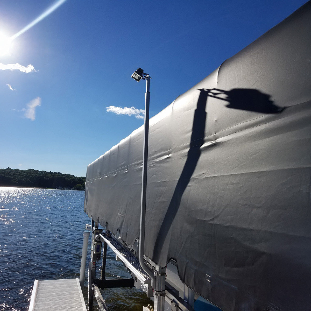 Boat docked at a pier with a clear blue sky and water in the background