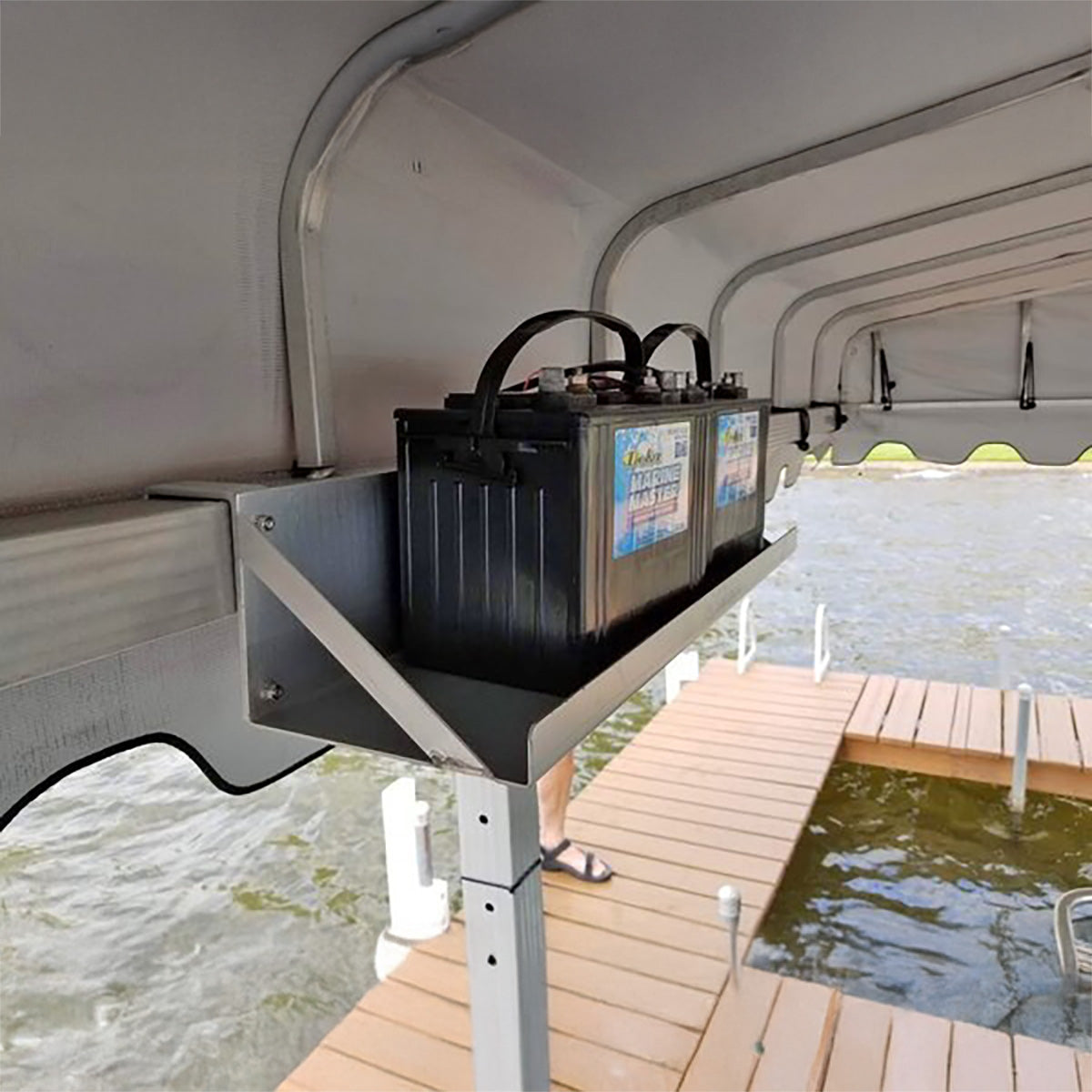 Dual hanging battery tray with two batteries mounted on a boat lift beside a dock