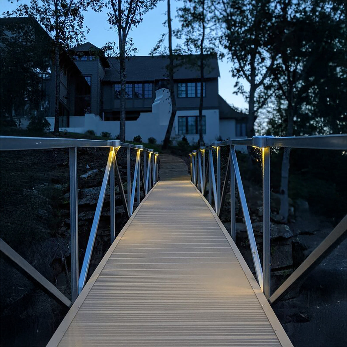 Solar rail lights glowing along a dock walkway at dusk