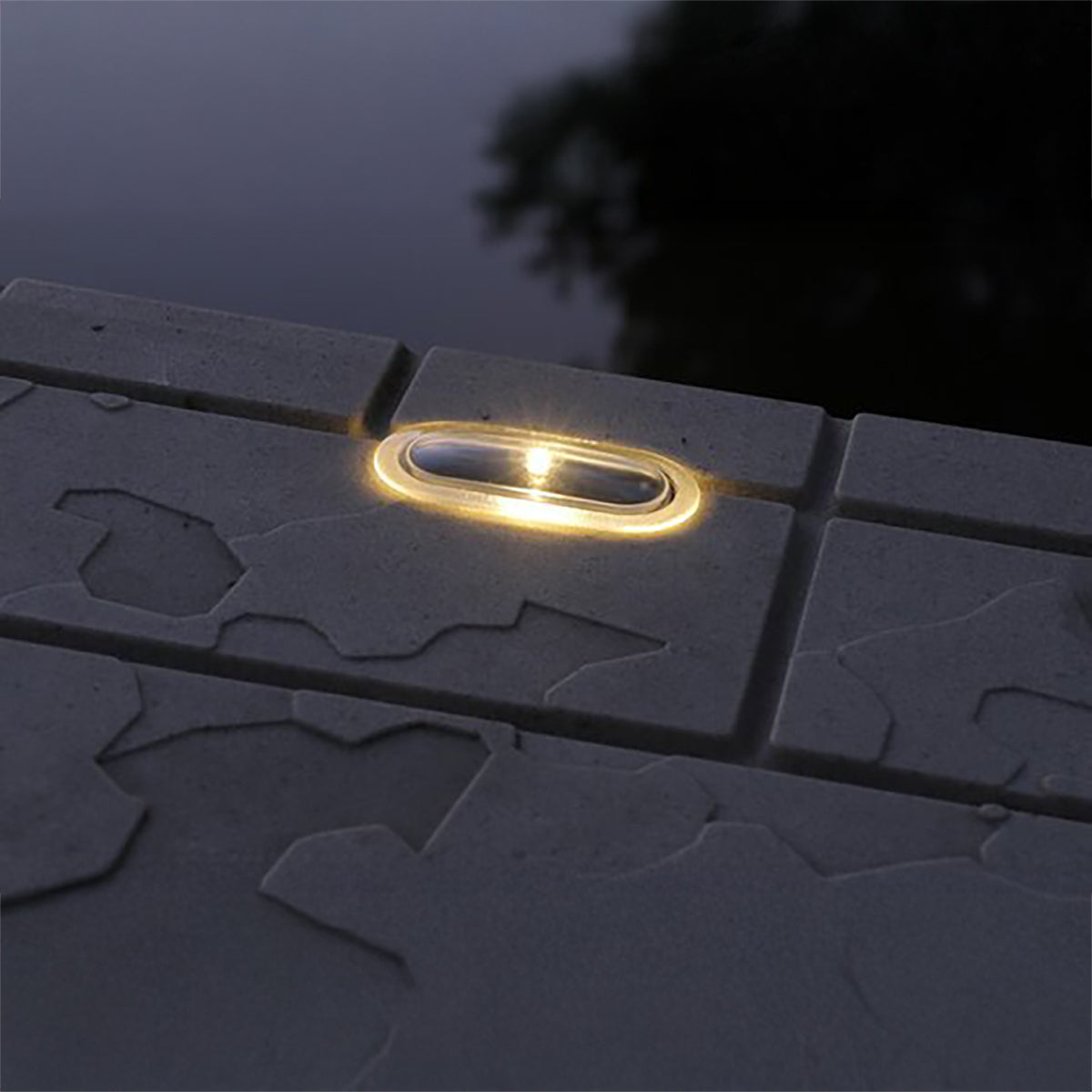 Solar light embedded in a dark concrete surface with a blurred background