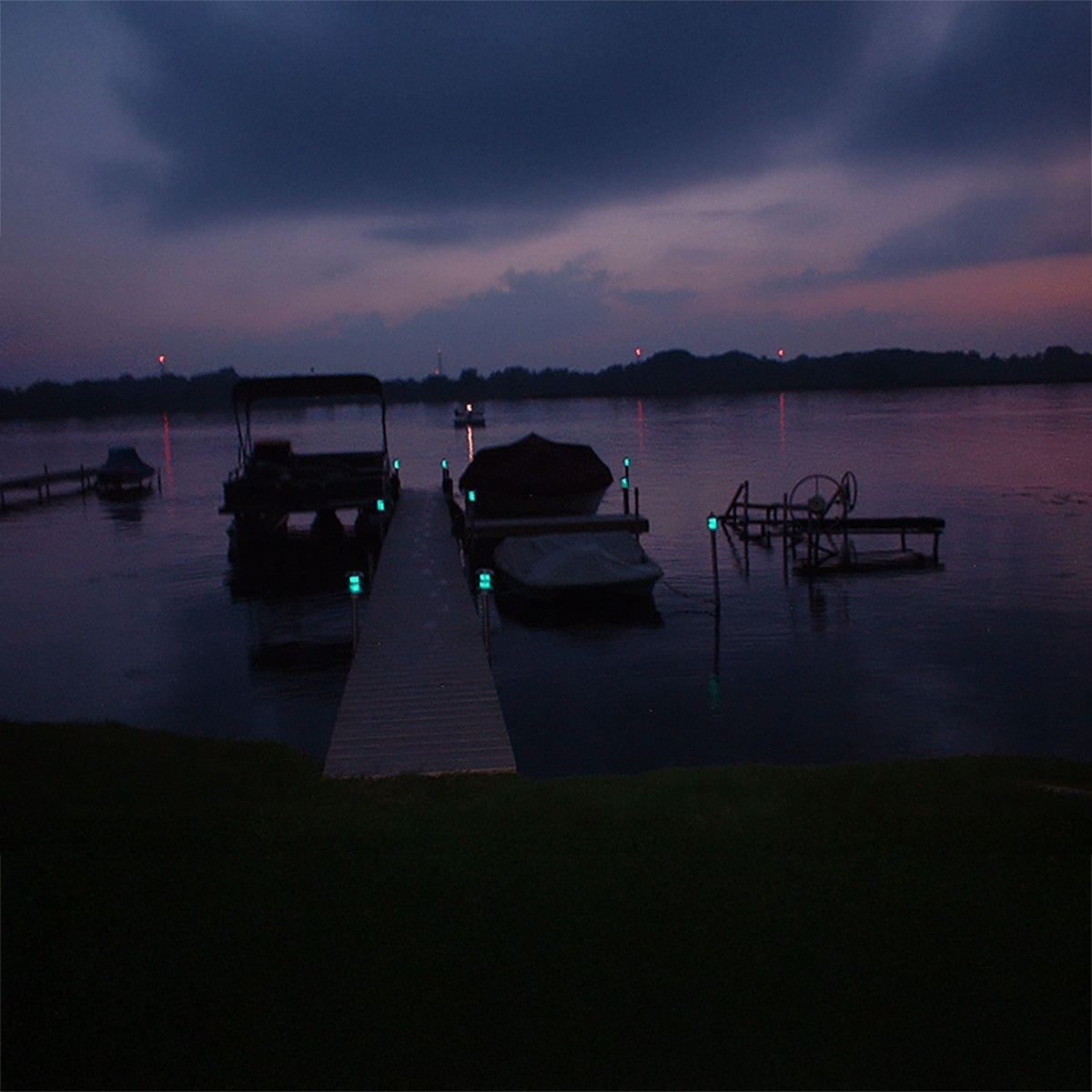 Boats on a dock at dusk with a dark sky