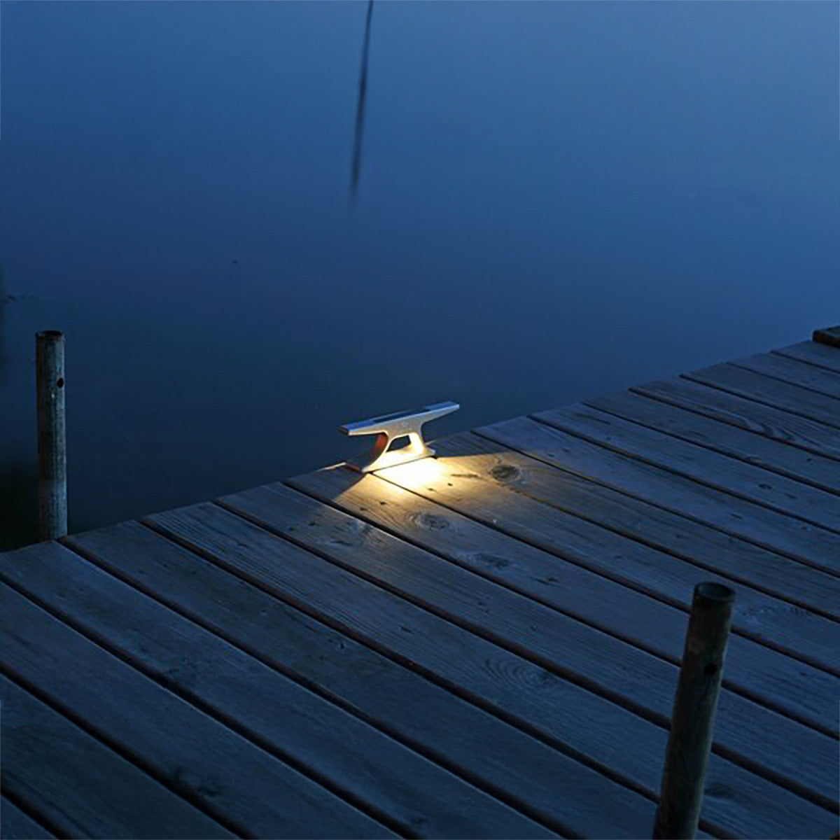 Wooden dock with a light fixture at night