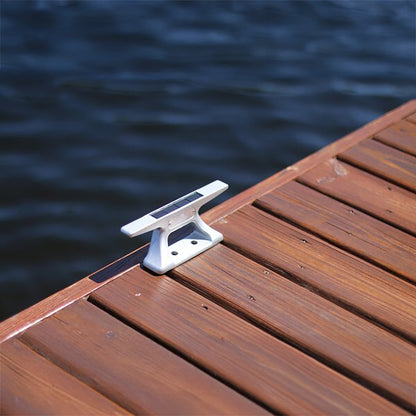 White cleat on a wooden dock with water in the background