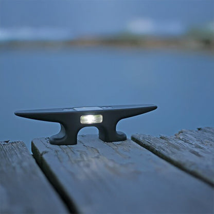 Solar light attached to a wooden dock with a blurred water background