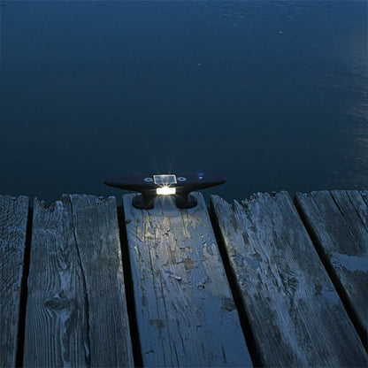 Light fixture on a wooden dock by a body of water at night