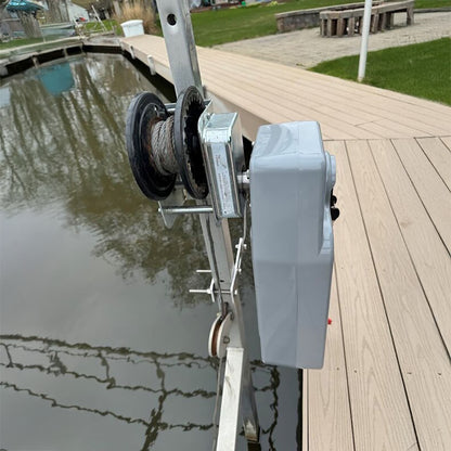Marine winch on a dock with water and grass in the background