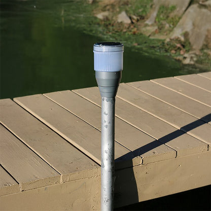 Outdoor light fixture on a wooden deck with grass in the background