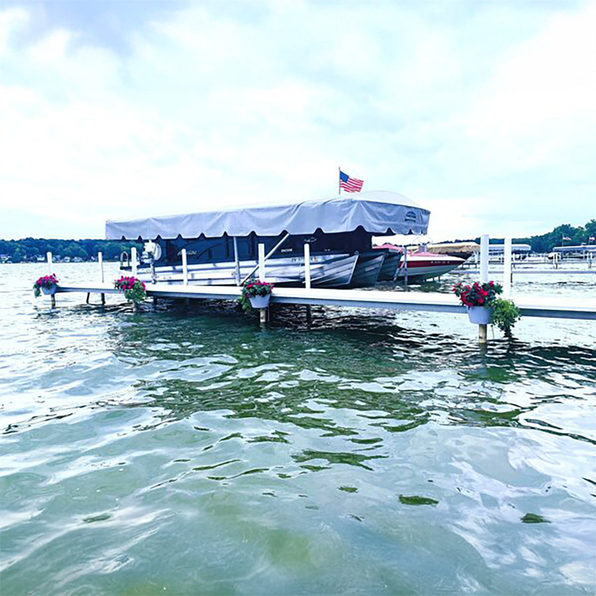 Dock with boats and flower pots on a calm lake