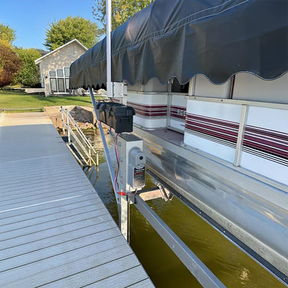Pontoon boat with an awning on a dock by a house