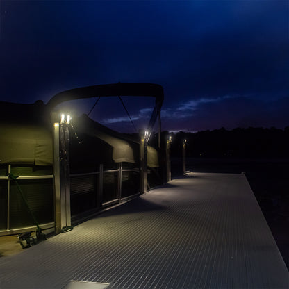 Boat on a dock at night with lights illuminating the area