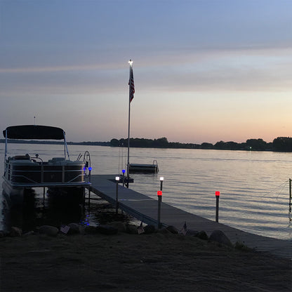Boat docked at a pier with an American flag during sunset.