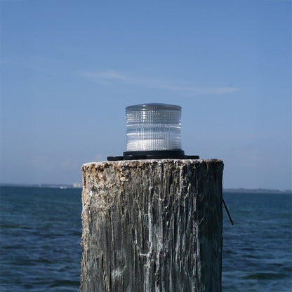 Light fixture on a wooden post with ocean and sky in the background
