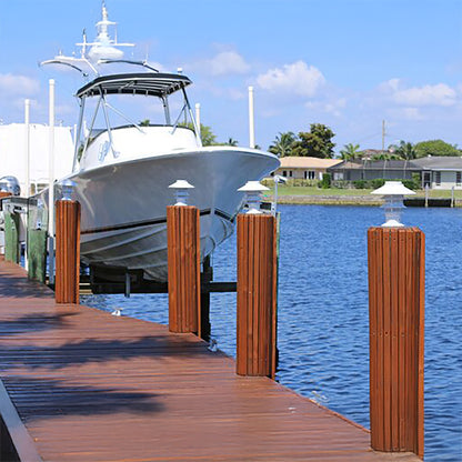 White boat docked at a wooden pier with a clear blue sky and water.