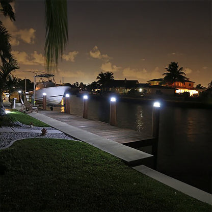 Evening view of a dock with a boat and surrounding houses.