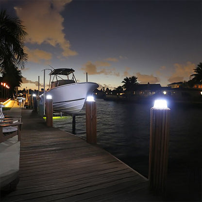 Boat on a dock at night with illuminated posts
