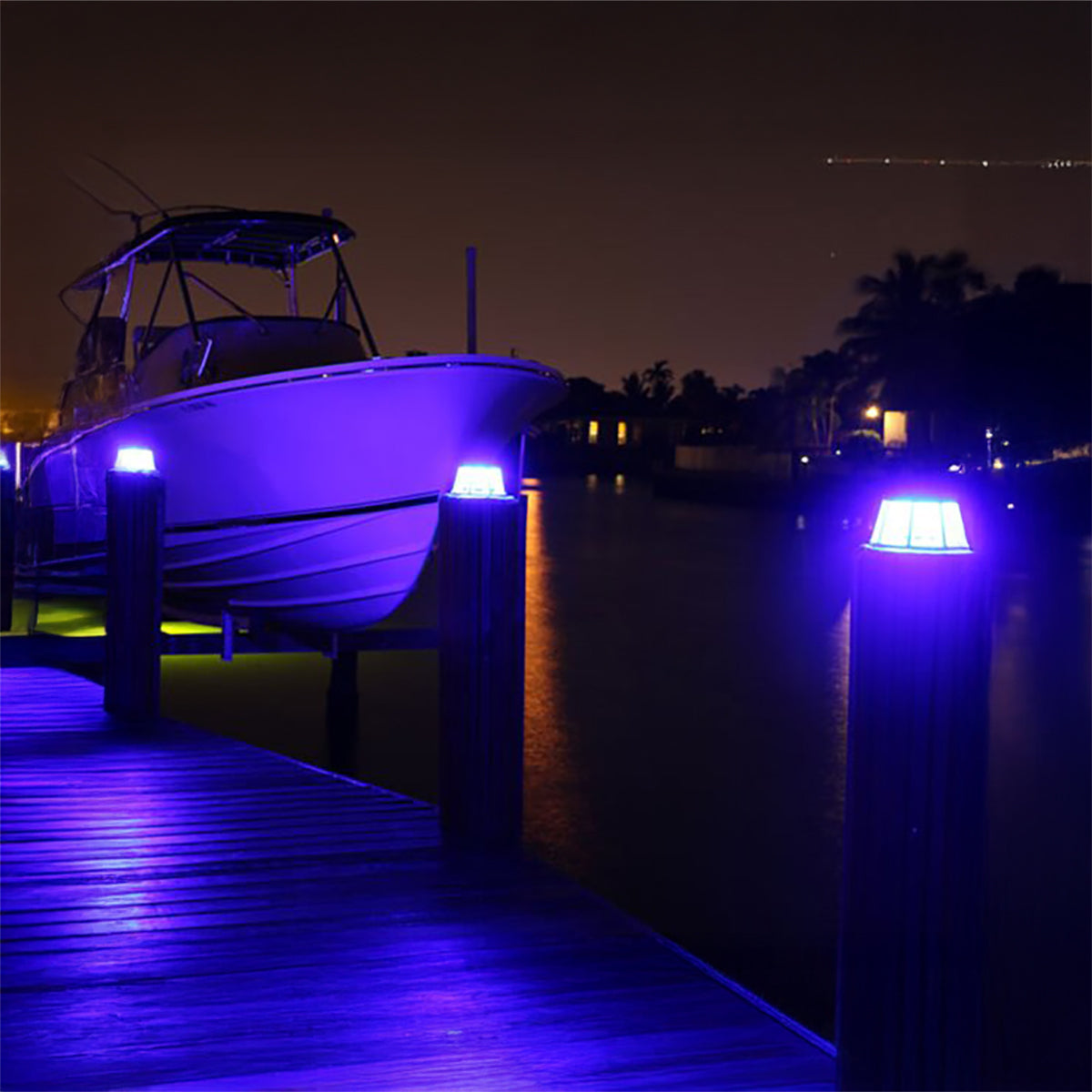 Boat docked at a pier with purple lighting at night