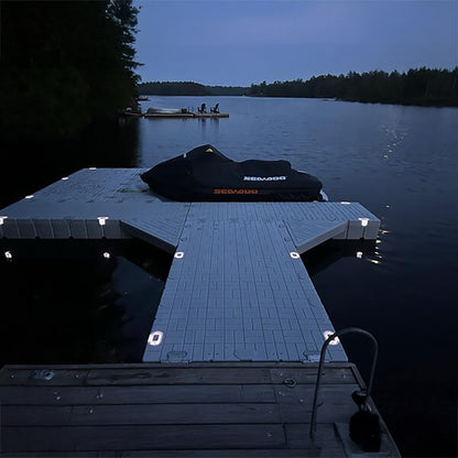 Dock with a covered boat on a lake at night