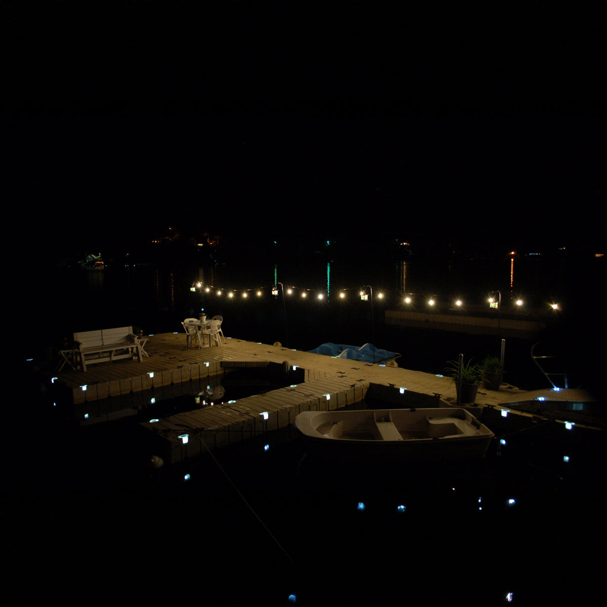 Evening dock scene with lights and a boat at night