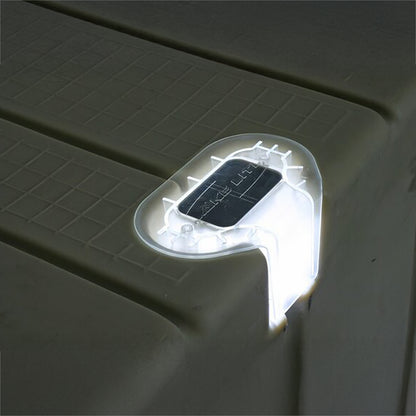 Solar-powered LED light attached to a dark surface
