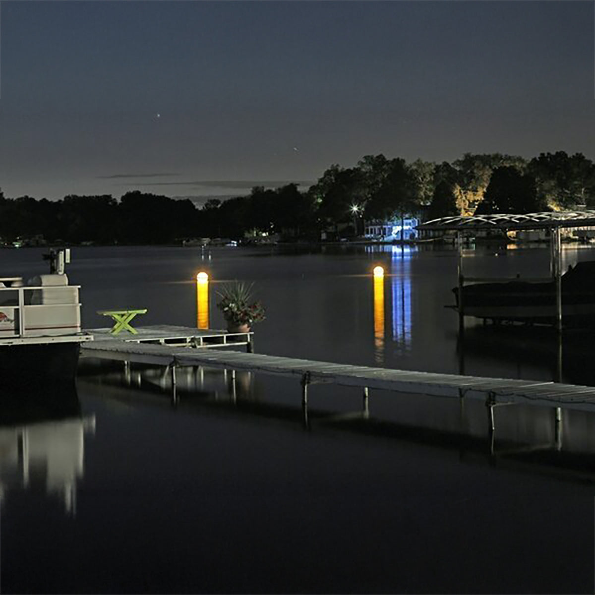 Evening scene at a dock with lights reflecting on water