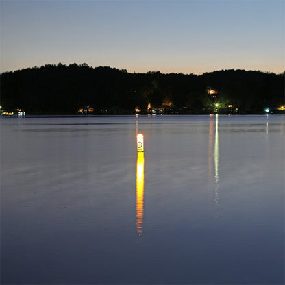 Lighthouse on a lake at night with reflection