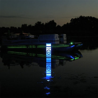 LED buoy glowing blue and green on a body of water at night