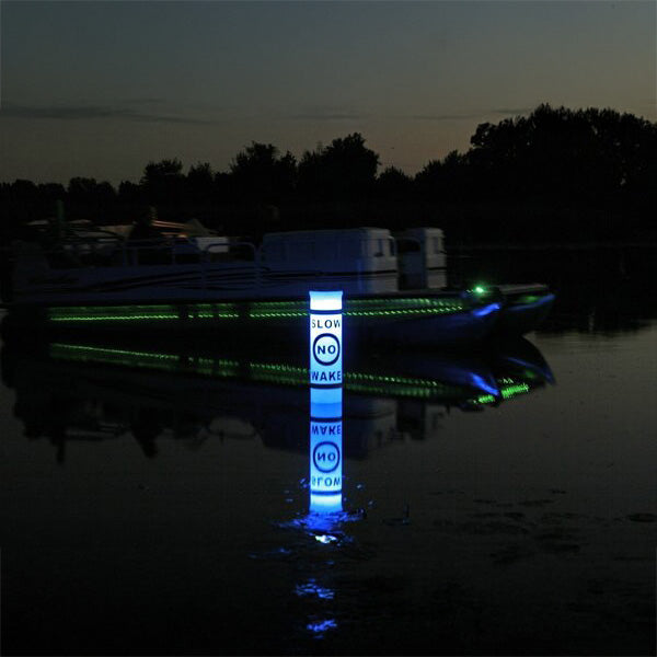 LED buoy glowing blue and green on a body of water at night