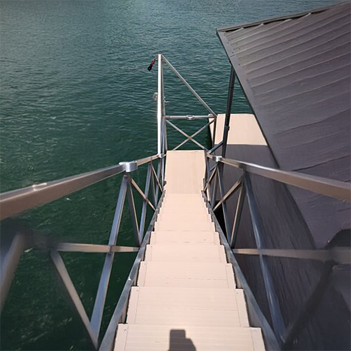 Stairway leading down to a body of water with a metal railing.