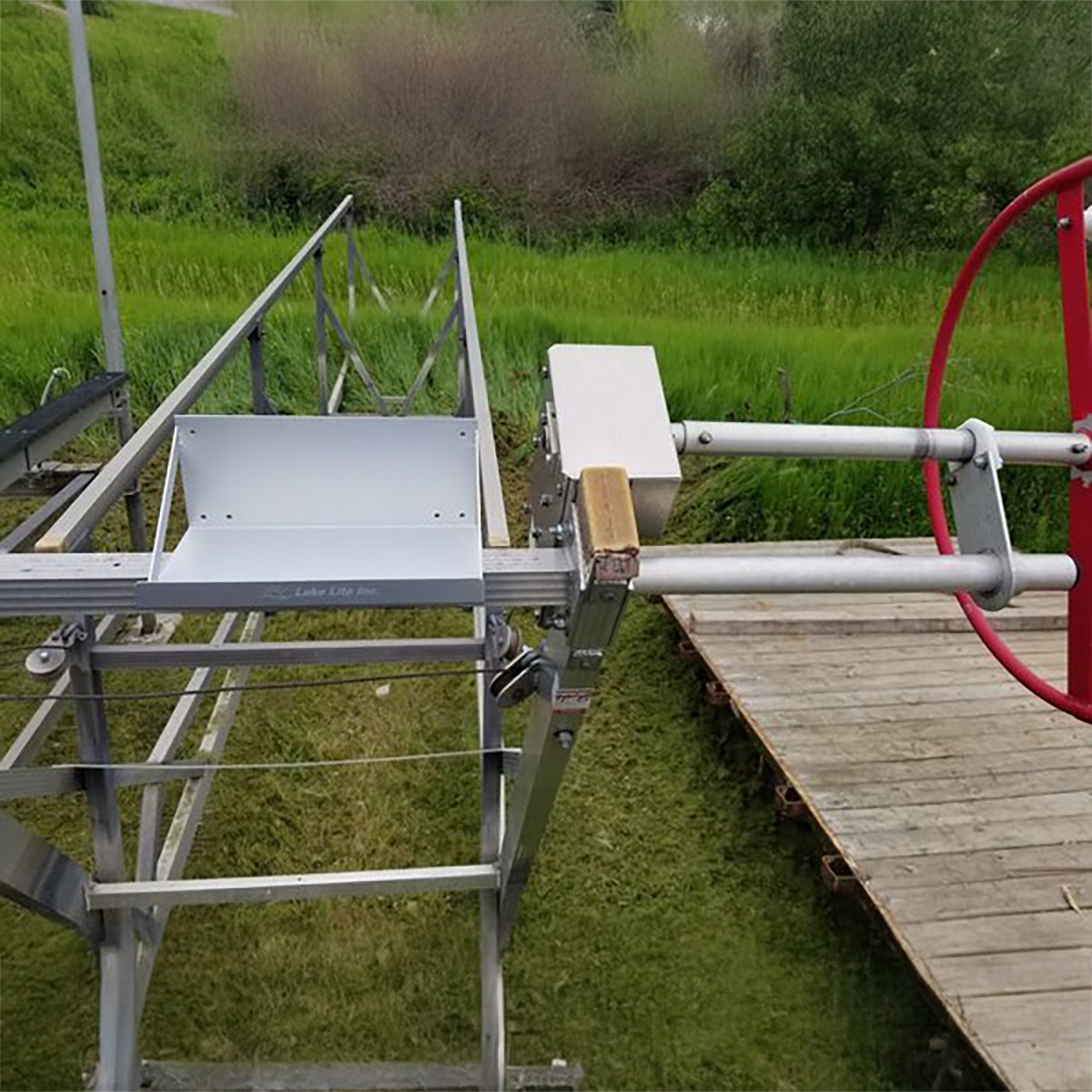 Empty single cantilever battery tray installed on a boat lift beside a dock