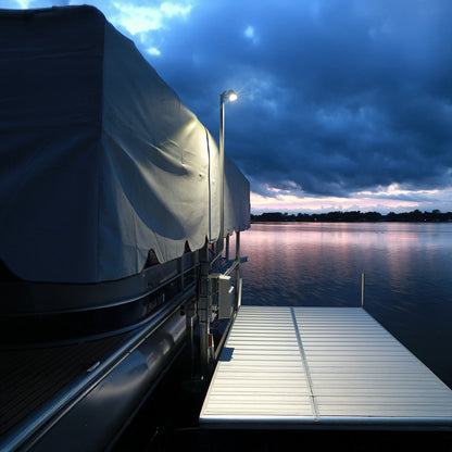 Covered boat on a dock at dusk with a cloudy sky
