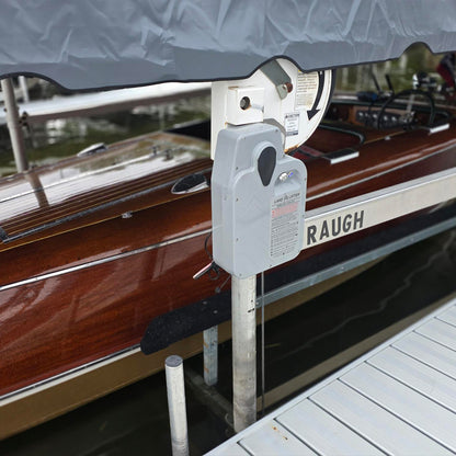 Lake Lifter direct drive motor mounted on a boat lift beside a wooden runabout