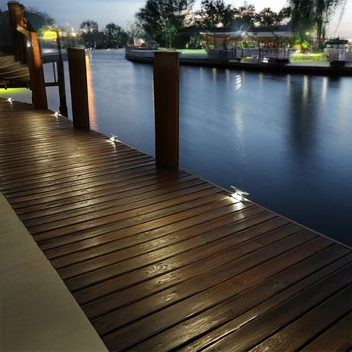 Aluminum solar cleat lights glowing along the edge of a wooden dock at night