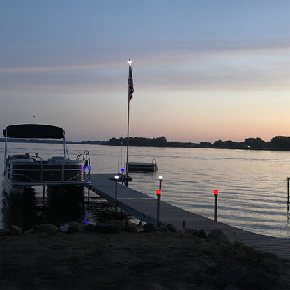 Boat docked at a pier with an American flag during sunset.