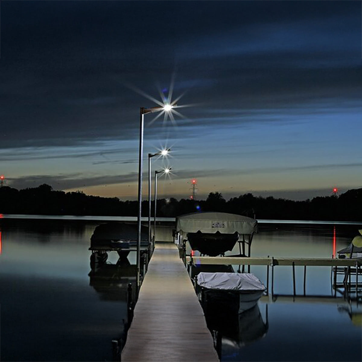 Dock with chairs and lights at night on a lake