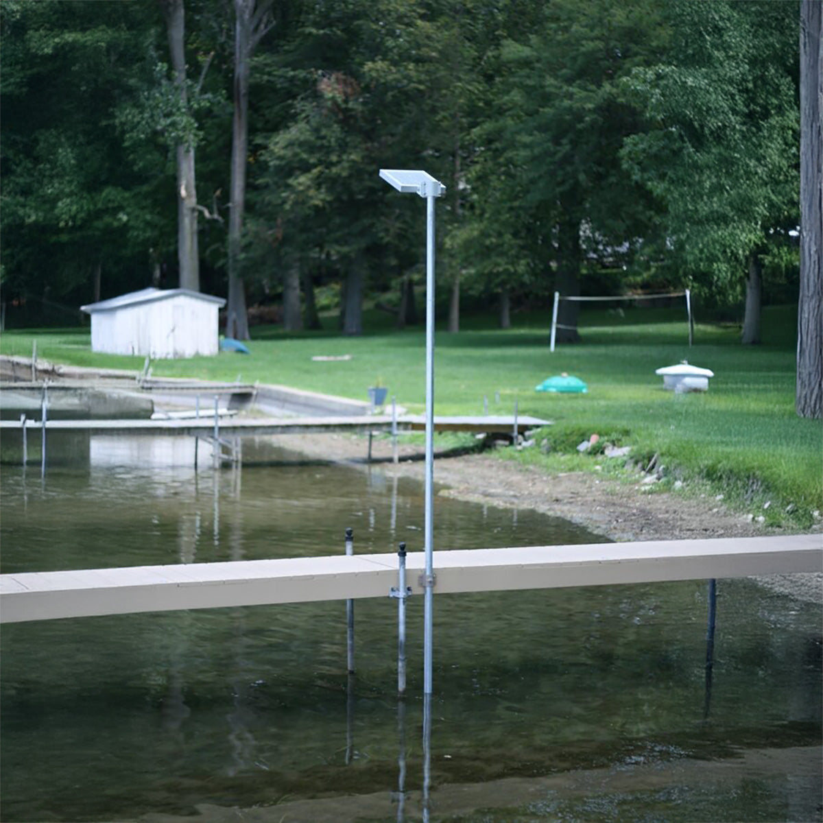 Dock extending into a body of water with trees and grass in the background