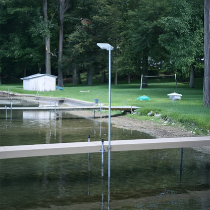 Dock extending into a body of water with trees and grass in the background